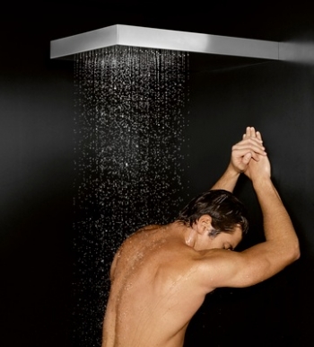 Ein Mann duscht unter einer Dornbracht BigRain Regendusche